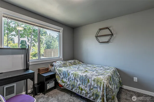 a bedroom with a bed and windows