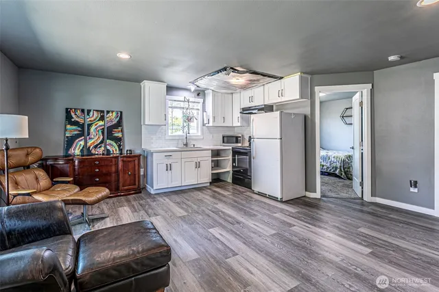 a living room with furniture and a kitchen area