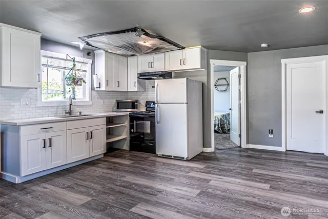 a kitchen with a refrigerator and white cabinets