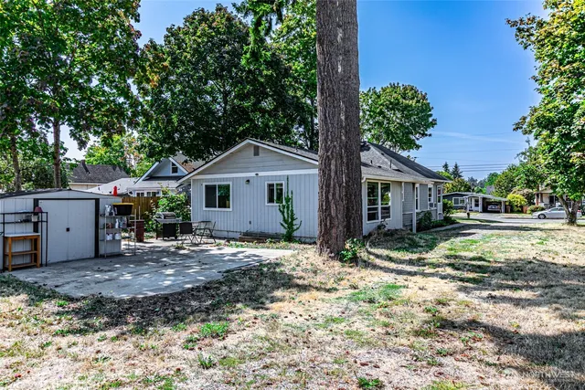 a view of a house with a yard and large tree