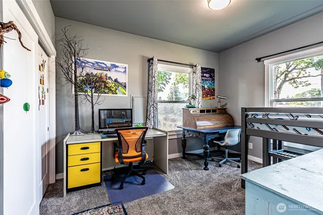 a view of a workspace with furniture and a window