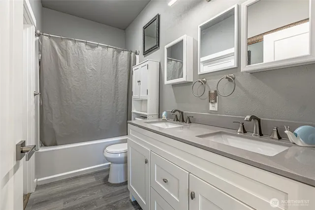 a bathroom with a granite countertop sink toilet and shower