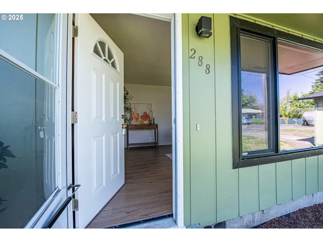 a view of a hallway with wooden floor and windows