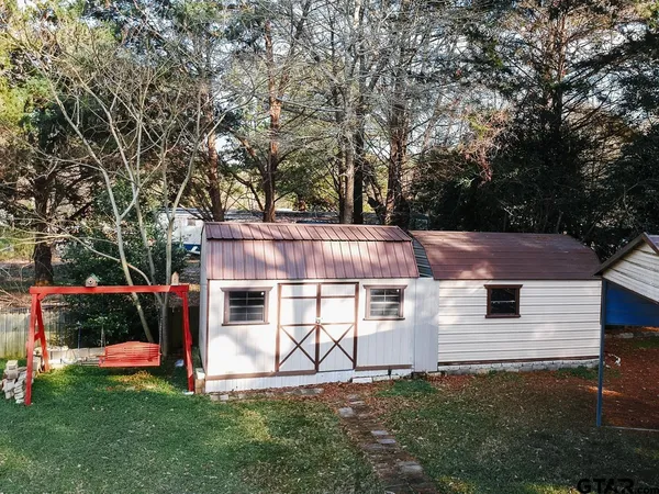 a view of a house with backyard and a tree