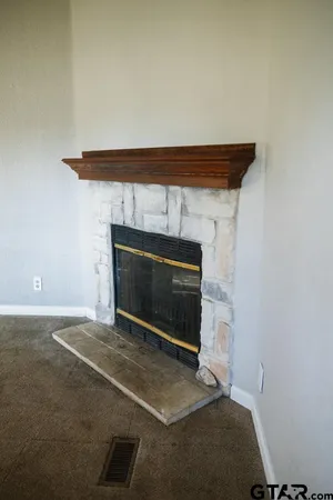 a view of an empty room with a fireplace and a window