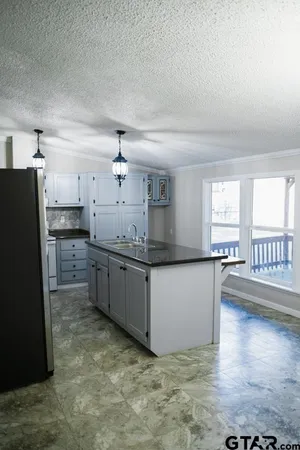 a kitchen with stainless steel appliances granite countertop a refrigerator a stove and a sink