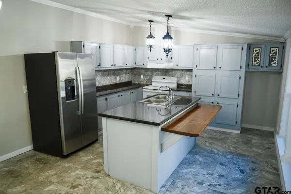 a kitchen with a sink a stove and chandelier