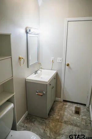 an empty room with wooden floor fan and window