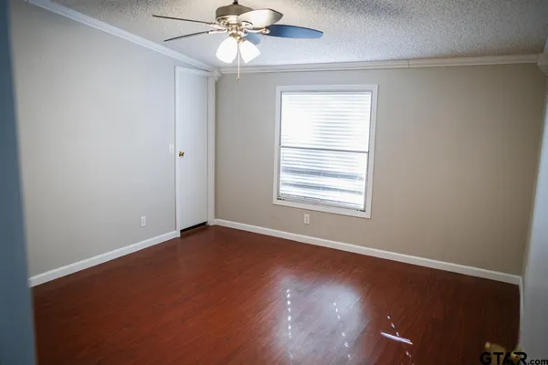 a view of an empty room with wooden floor