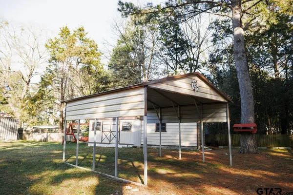 a view of a white house with a big yard and large trees