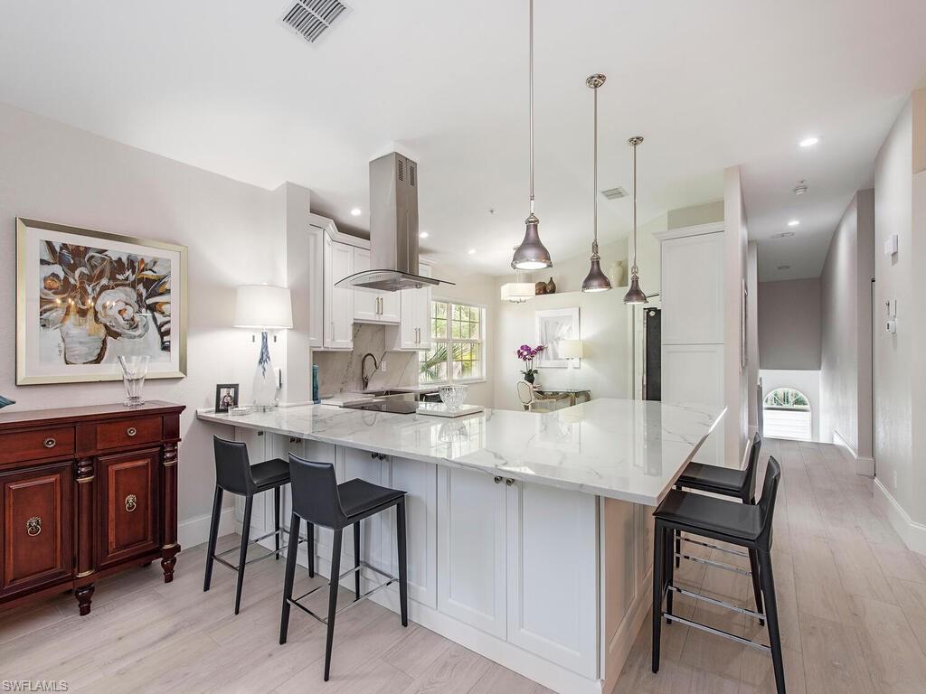 a kitchen with stainless steel appliances kitchen island a table and chairs in it