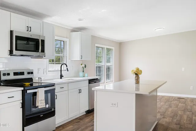 a kitchen with a sink stove top oven and microwave