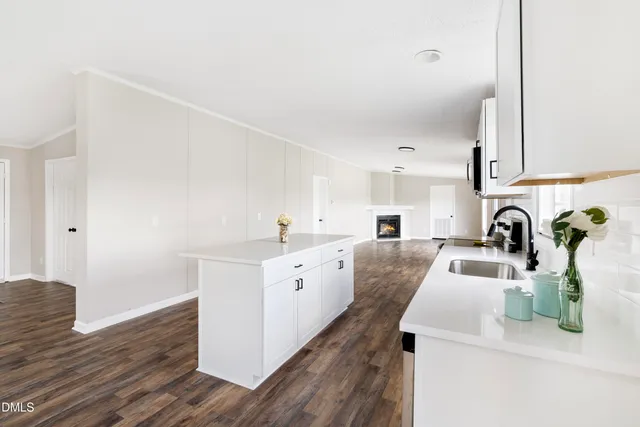 a kitchen with white cabinets and sink