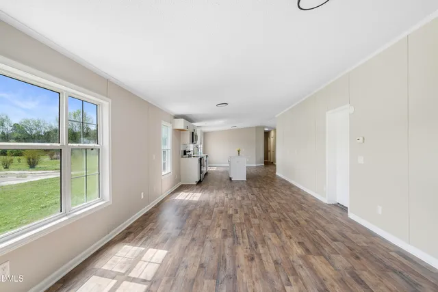 a view of a livingroom with wooden floor and a window