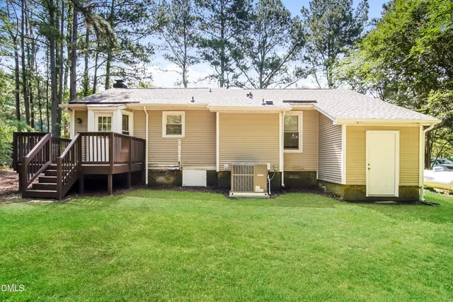 a view of a yard with large trees and a barn