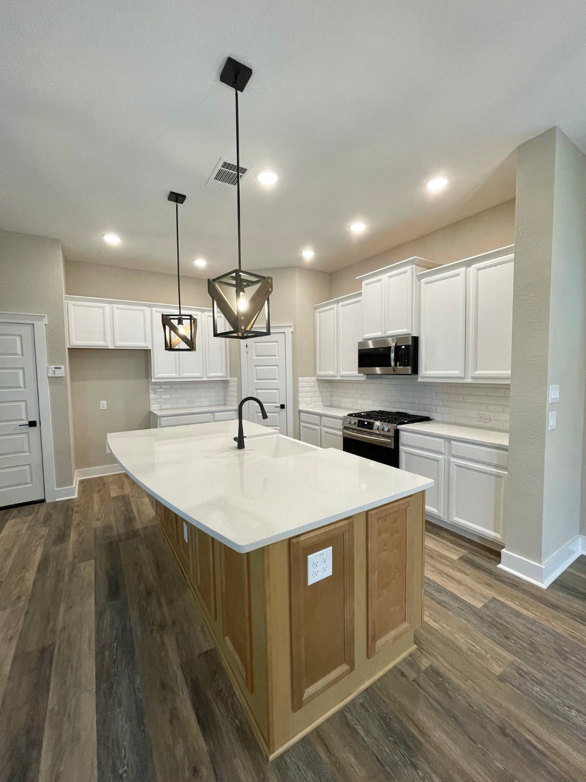 18607 Courteous Way Cypress, TX 77433 - Photo 10 of 37 a kitchen with kitchen island a sink stainless steel appliances and wooden floor