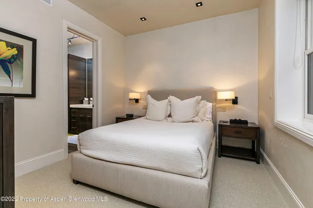 a bedroom with a bed and a painting on the wall