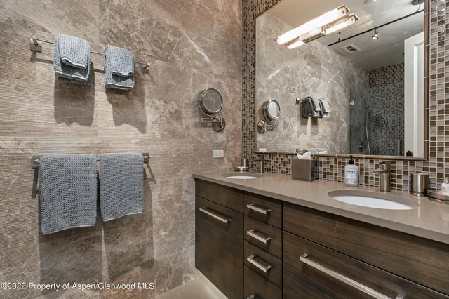 a bathroom with a double vanity sink mirror and shower