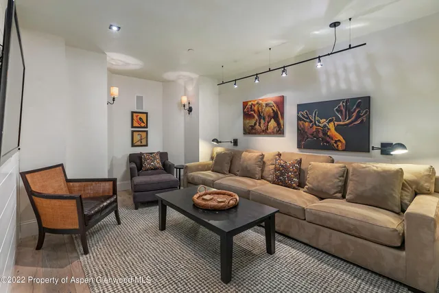 a living room with furniture a rug and a painting on the wall