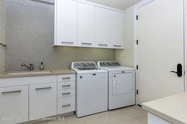 a utility room with cabinets washer and dryer