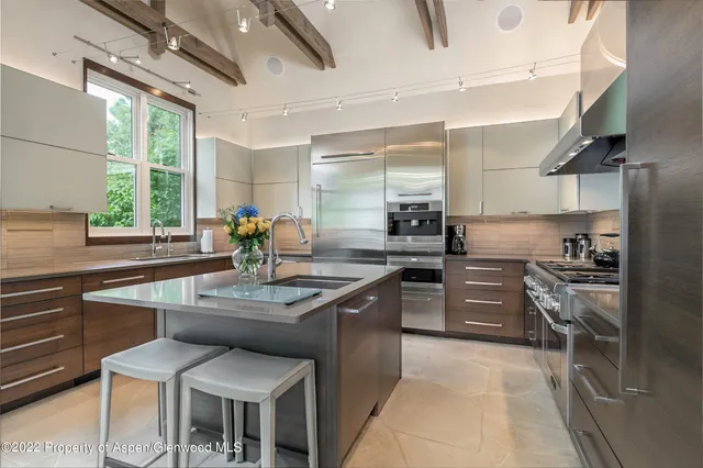 a kitchen with stainless steel appliances granite countertop a sink and a refrigerator