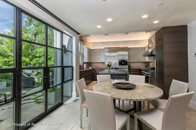 a kitchen with a table chairs refrigerator and cabinets