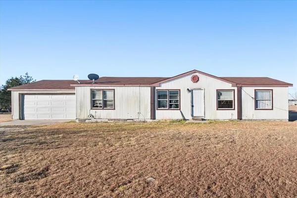 a front view of a house with a garden and yard