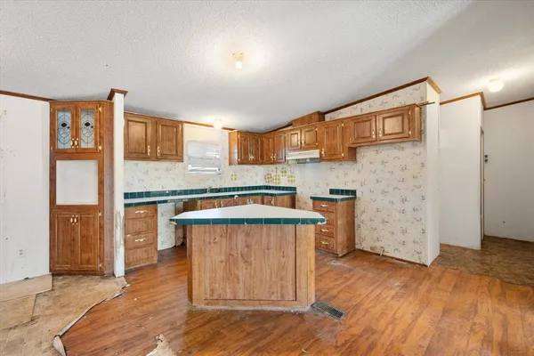 a kitchen with granite countertop wooden floors and a fireplace