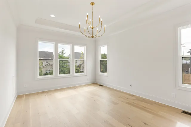 an empty room with windows and chandelier