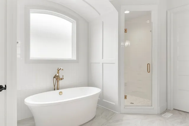 a white bath tub sitting next to a shower
