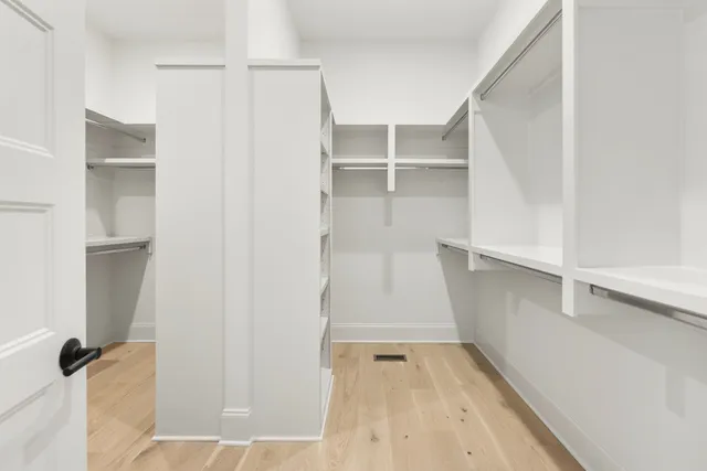 a view of walk in closet with empty racks