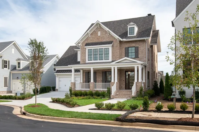 a front view of a house with a yard and potted plants