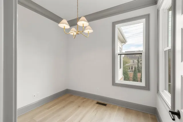 an empty room with a window and wooden floor
