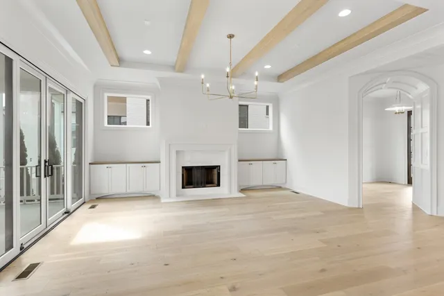 a view of an empty room with a fireplace and a window