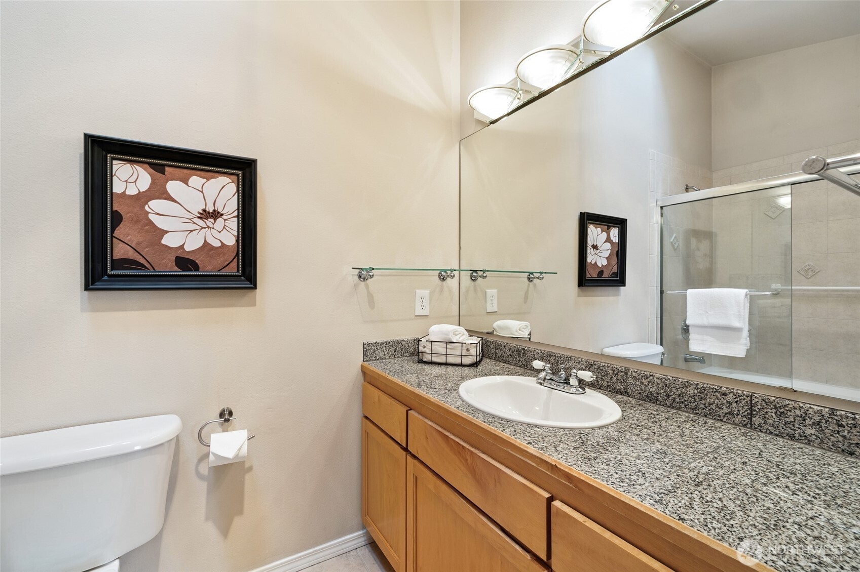 1512 Northwest 57th Street, Unit B Seattle, WA 98107 - Photo 22 of 27 a bathroom with a granite countertop sink a mirror and a toilet