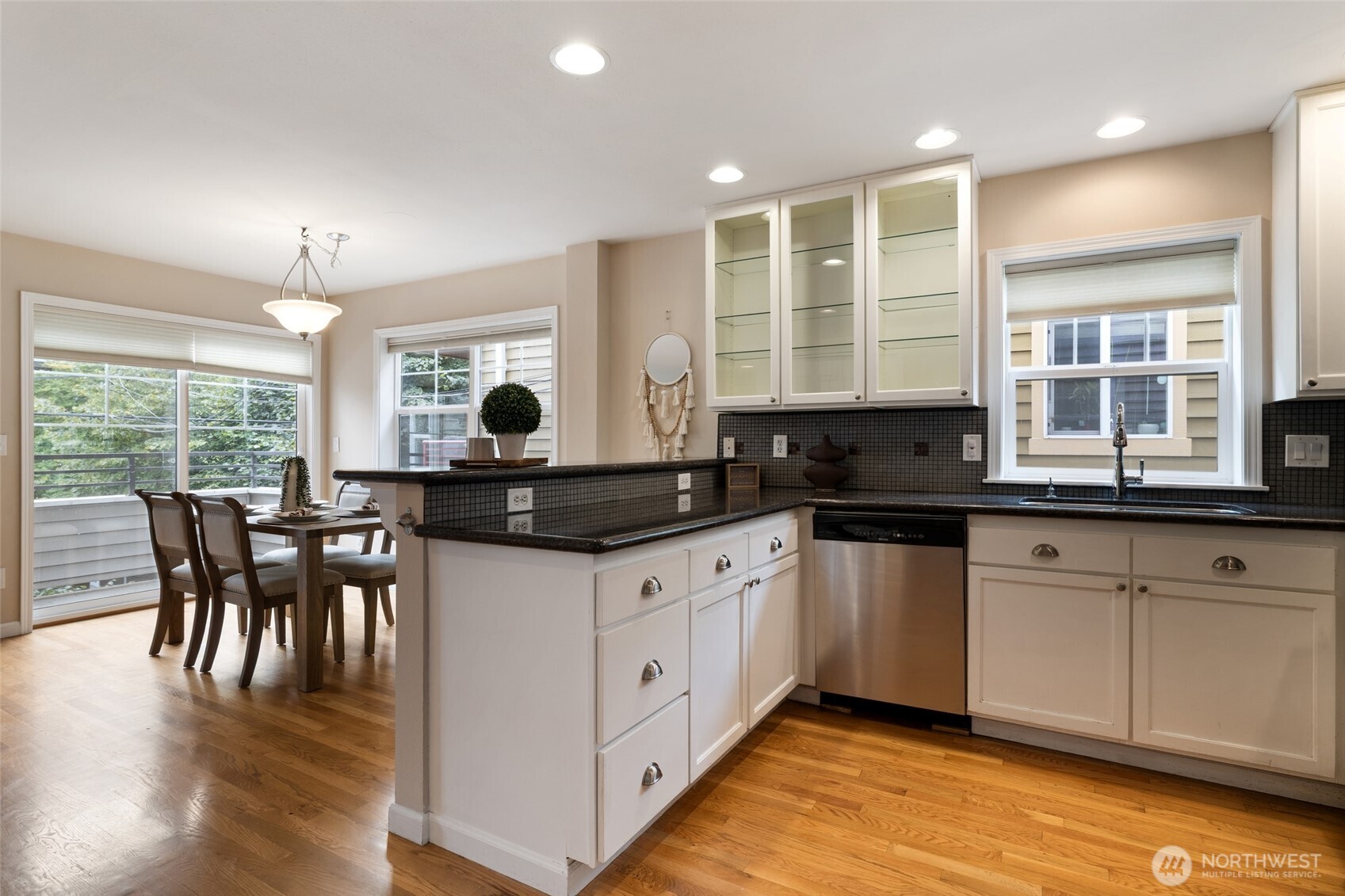 1512 Northwest 57th Street, Unit B Seattle, WA 98107 - Photo 3 of 27 a kitchen with granite countertop a stove a sink a dining table and chairs