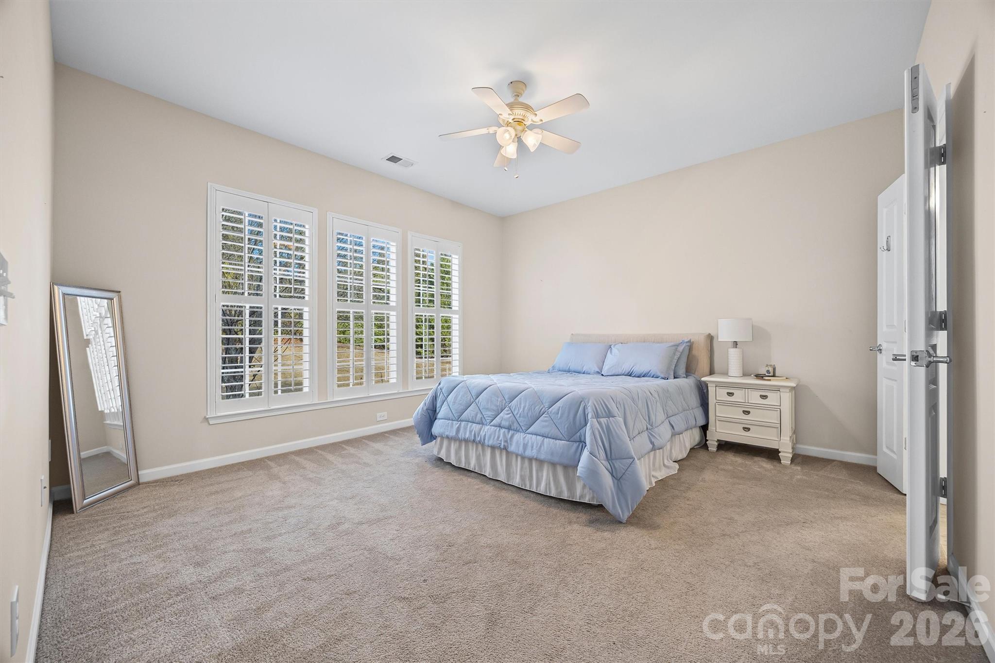 2227 Lilac Lane Fort Mill, SC 29707 - Photo 13 of 42 a spacious bedroom with a bed and a chandelier