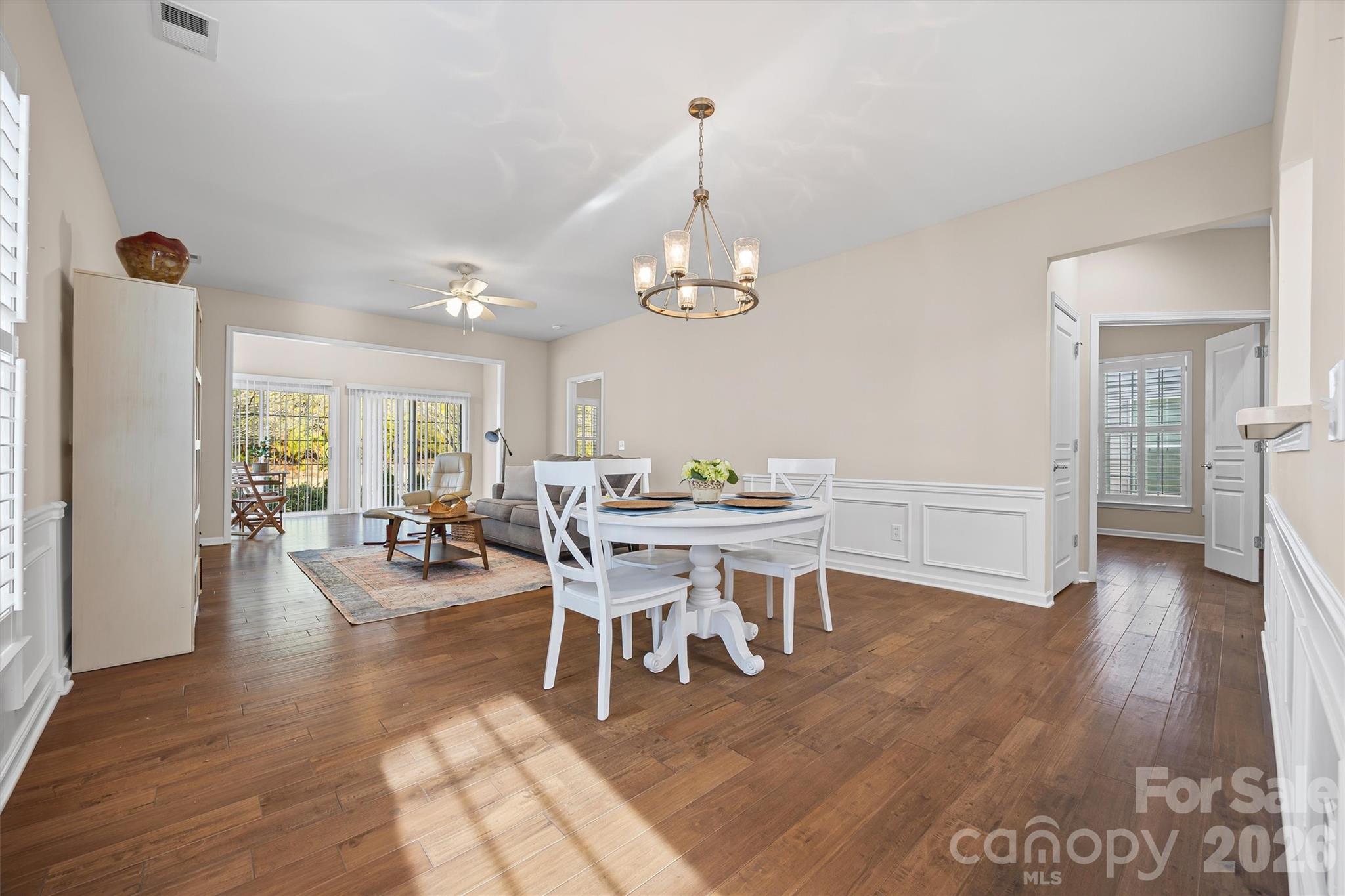 2227 Lilac Lane Fort Mill, SC 29707 - Photo 9 of 42 a dining room with wooden floor a chandelier a wooden table and chairs