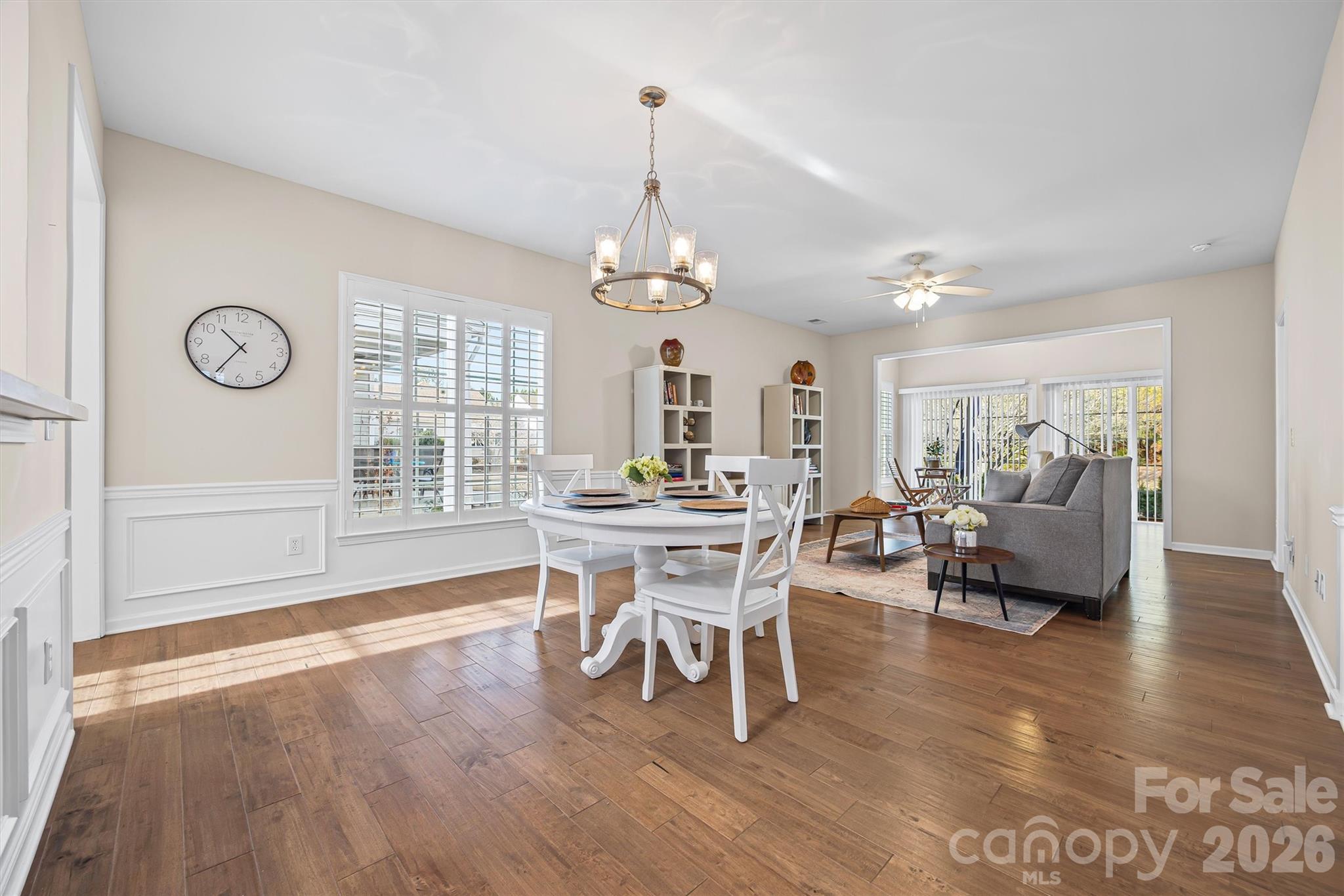 2227 Lilac Lane Fort Mill, SC 29707 - Photo 10 of 42 a dining room with wooden floor a chandelier a wooden table and chairs