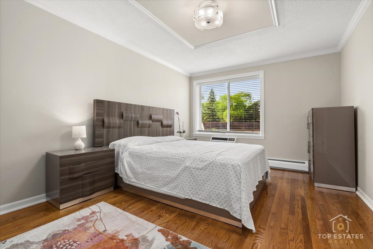 1227 South Old Wilke Road, Unit 201 Rolling Meadows, IL 60005 - Photo 18 of 40 a bed sitting in a bedroom next to a window