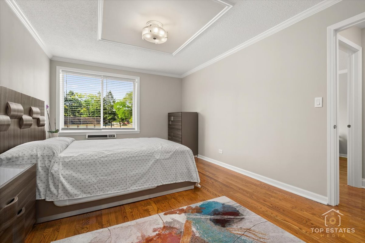 1227 South Old Wilke Road, Unit 201 Rolling Meadows, IL 60005 - Photo 19 of 40 a bed sitting in a bedroom next to a window