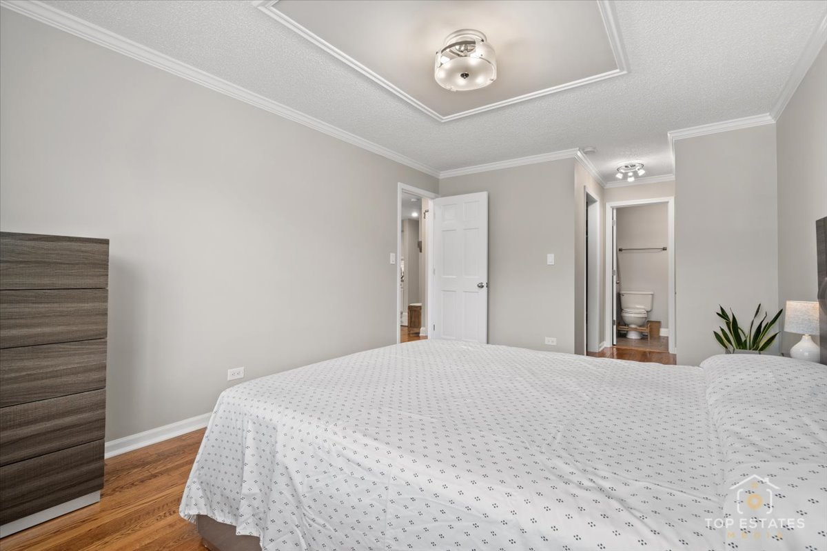 1227 South Old Wilke Road, Unit 201 Rolling Meadows, IL 60005 - Photo 20 of 40 a bedroom with a bed and a chandelier