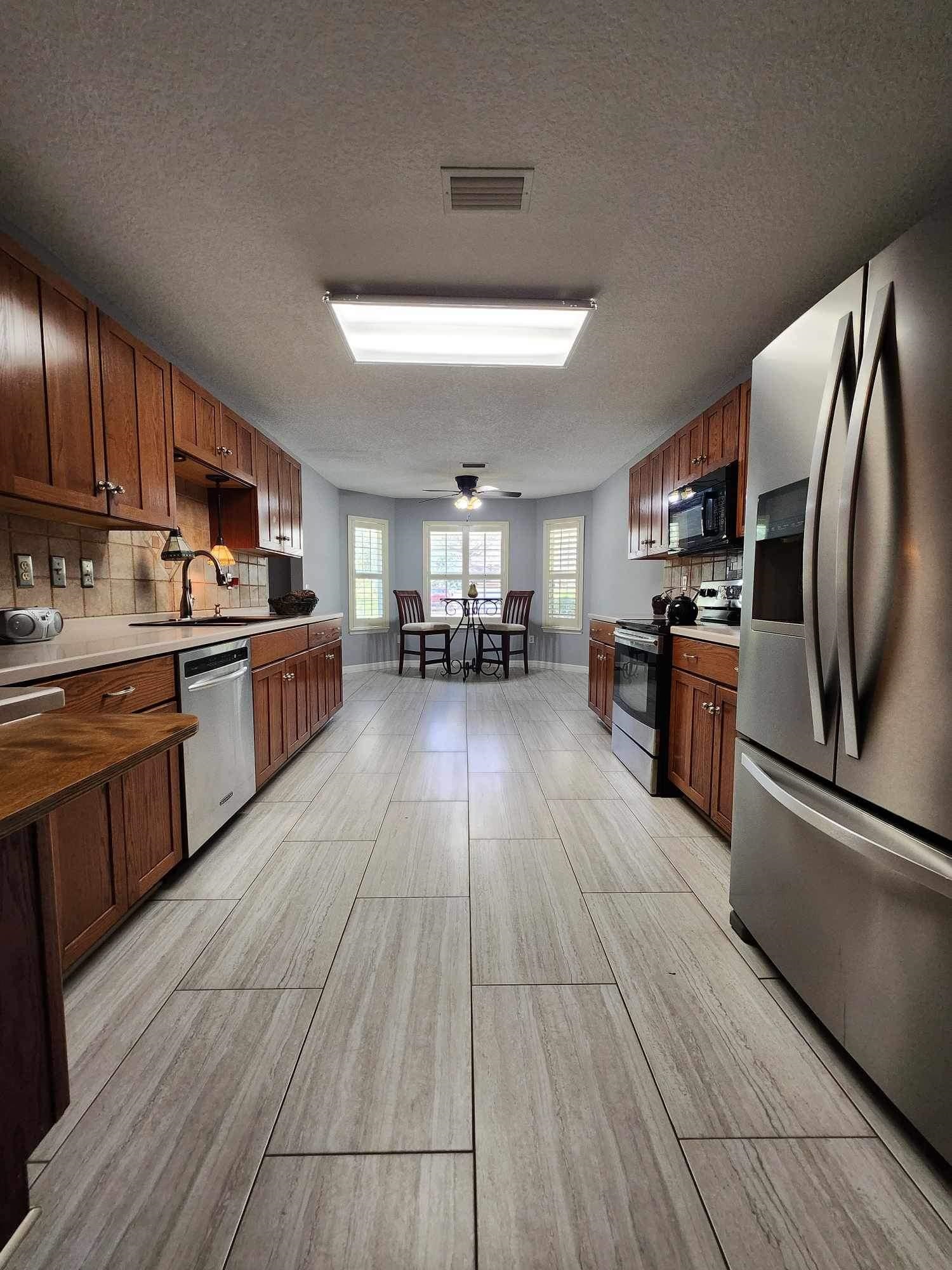 118 Martin Road St. Augustine, FL 32086 - Photo 8 of 34 a kitchen with stainless steel appliances granite countertop hardwood floor sink stove dining table and chairs