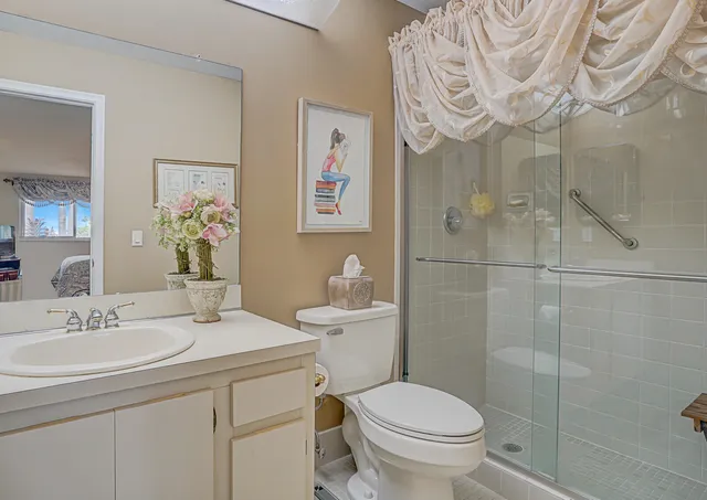 a bathroom with a sink a toilet and shower