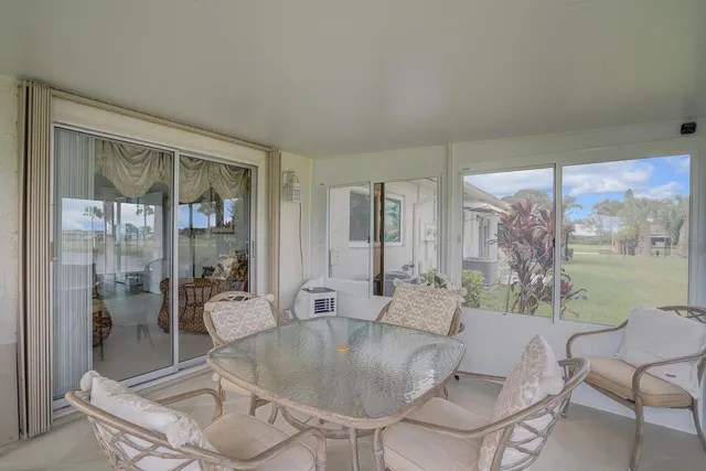 a living room with a glass table and windows