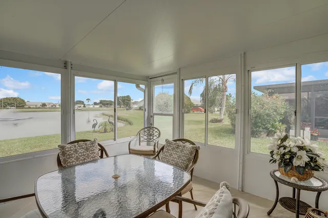 a living room with furniture and floor to ceiling windows