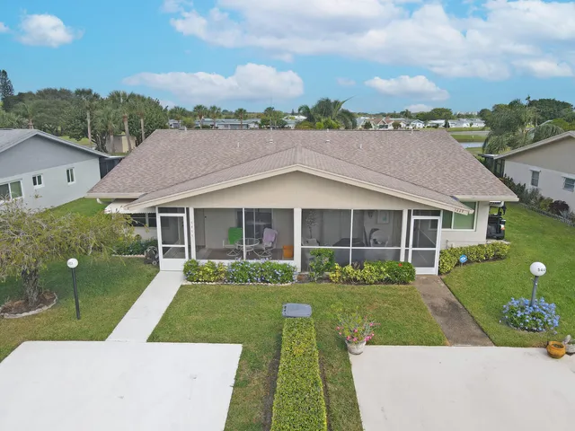a view of a house with a yard and potted plants