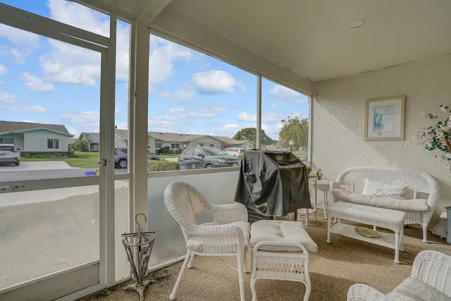 a dining room with furniture water view and a floor to ceiling window