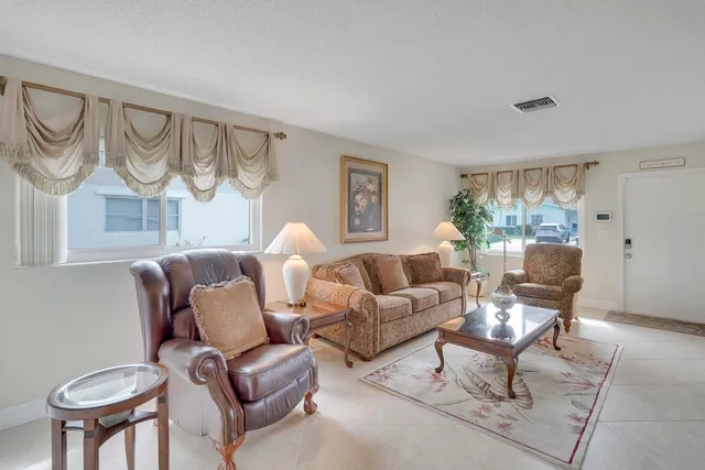 a living room with furniture a fireplace and a large window
