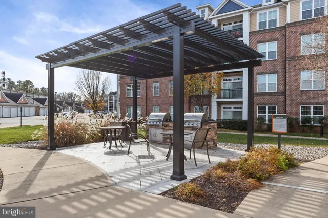 a view of a patio with a table and chairs under an umbrella with a large tree